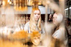 Two girls look at an open cryostat for superconducting quantum computing.