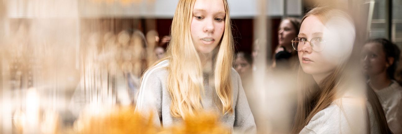 Two girls look at an open cryostat for superconducting quantum computing.