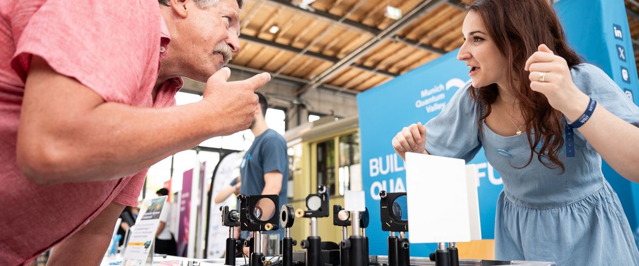 An MQV member explains an optical experiment to a visitor.