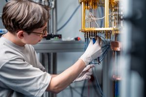 A scientist assembles cables on an open cryostat for superconducting quantum computing.