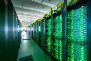 The SuperMUC-NG supercomputer at the Leibniz Supercomputing Centre: several server racks form a narrow aisle, numerous green LEDs light up.